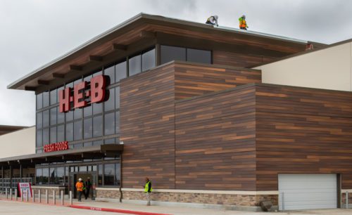 Fiberon composite cladding installed on the exterior façade of an H-E-B commercial building, showing modern wood-tone panels supplied by TimberTown.