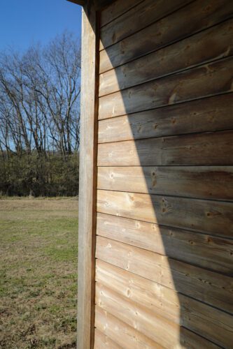 Close-up view of Kebony wood cladding on a Nashville exterior, showing natural weathering and warm modified-wood texture.