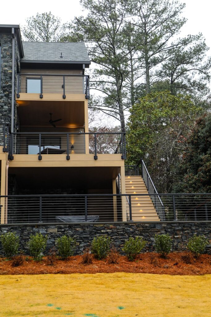 lake-windward-timbertech-deck-trespa-siding- Lakefront TimberTech deck surrounded by natural landscape.