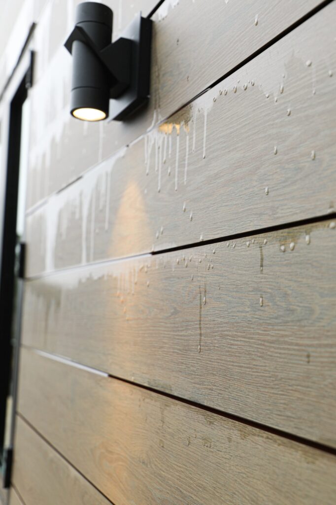 lake-windward-timbertech-deck-trespa-siding- Covered outdoor space with TimberTech decking by Boyce Design + Build.