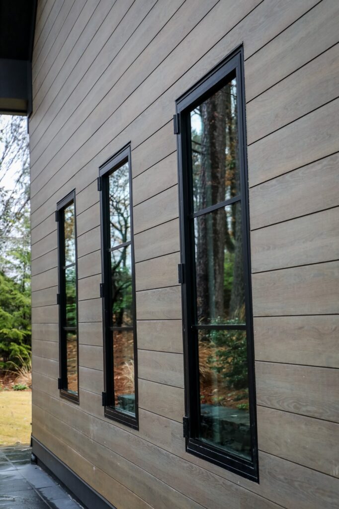 lake-windward-timbertech-deck-trespa-siding- TimberTech deck stairs wrapped with matching fascia boards.