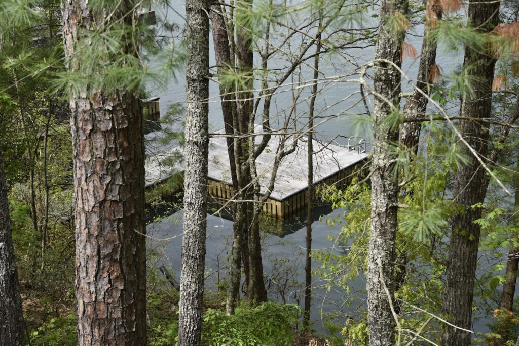 Accoya Grey siding surrounded by lake and tree reflections at the home’s main façade.