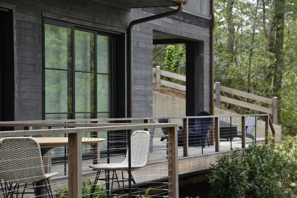 Ipe deck stairs shown in natural light at the home’s main façade.