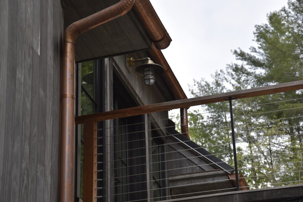 outdoor living space with modern black-framed windows overlooking the shoreline.