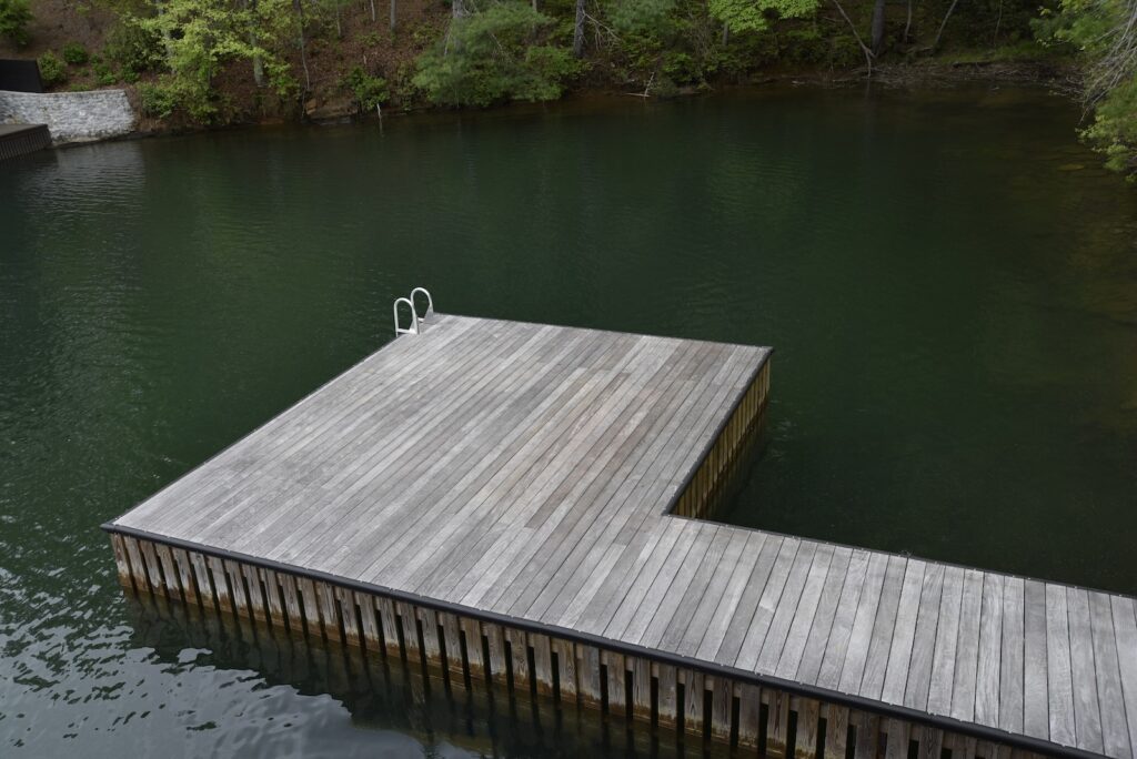 Ipe dock surface surrounded by lake and tree reflections on the lakeside elevation.