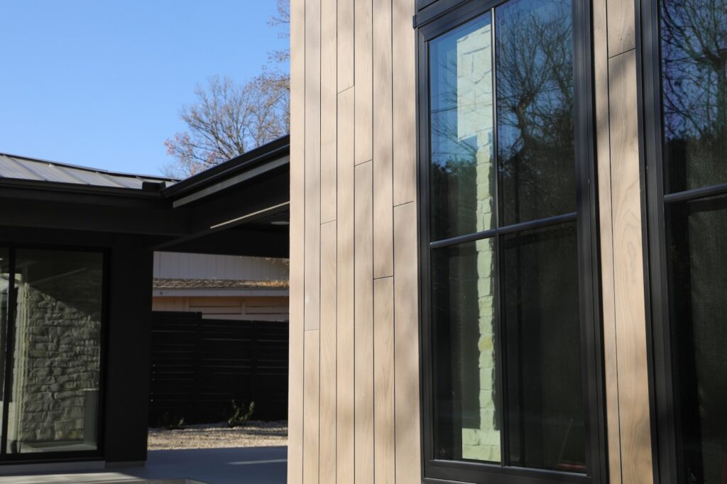 Thermory Benchmark Ash Vivid Silver vertical siding framing the contemporary exterior integrated into the architectural envelope.
