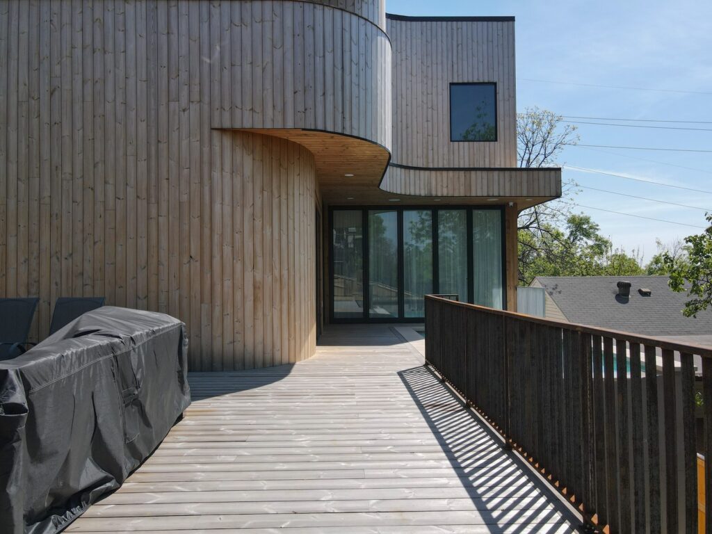Thermory knotty pine decking surface with modern railing detail