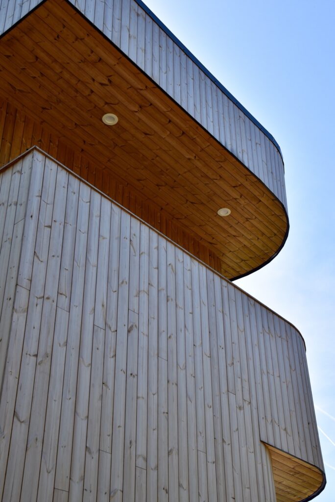 Wood exterior detail showing Thermory knotty pine and architectural curves
