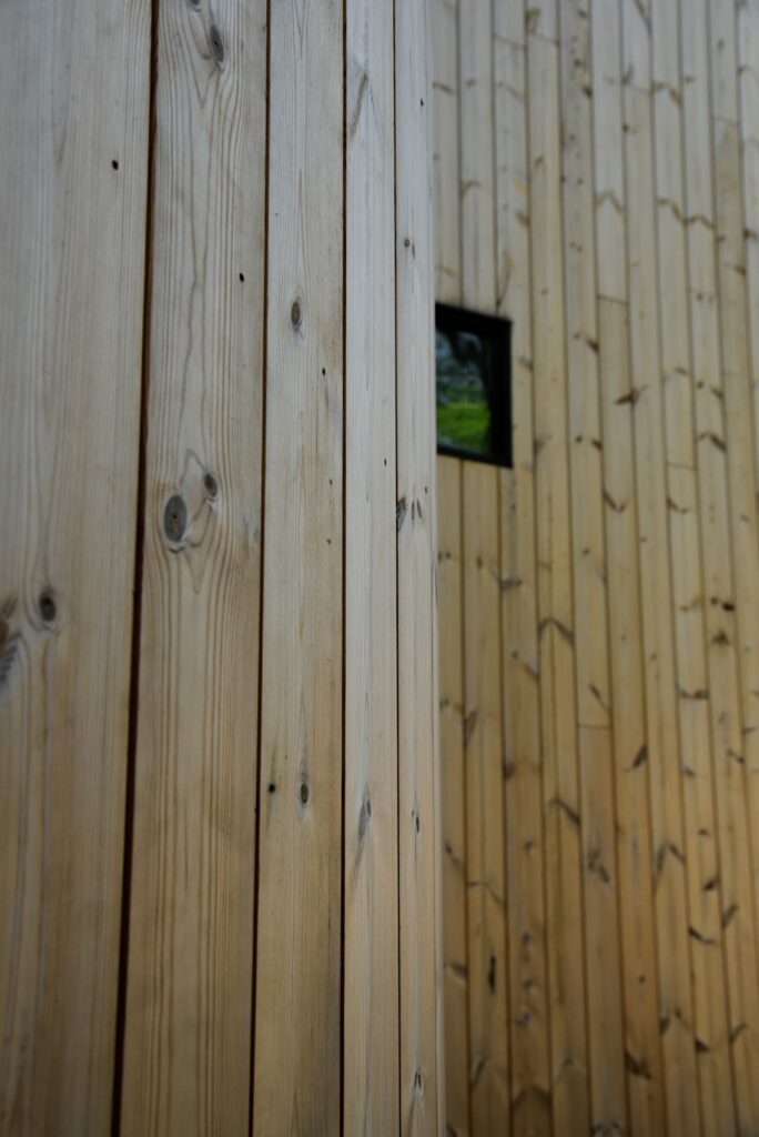 Close-up of Thermory knotty pine siding showing grain and knots