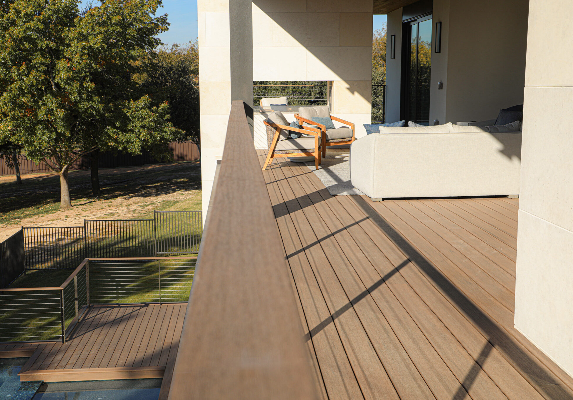 TimberTech composite decking with matching drink rail on patio above pool.